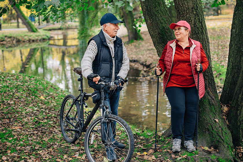 senior sport couple taking a short break on the bank of river under a tree for a while