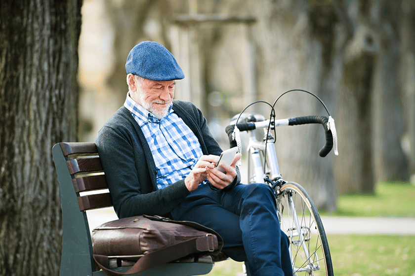 senior man with sitting on the bench with cycle on the side