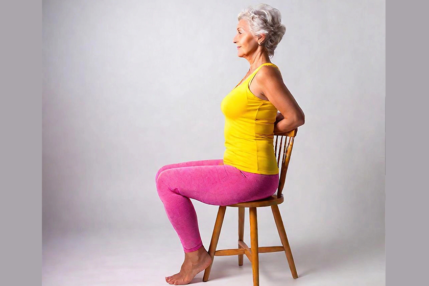 Senior woman doing yoga on chair